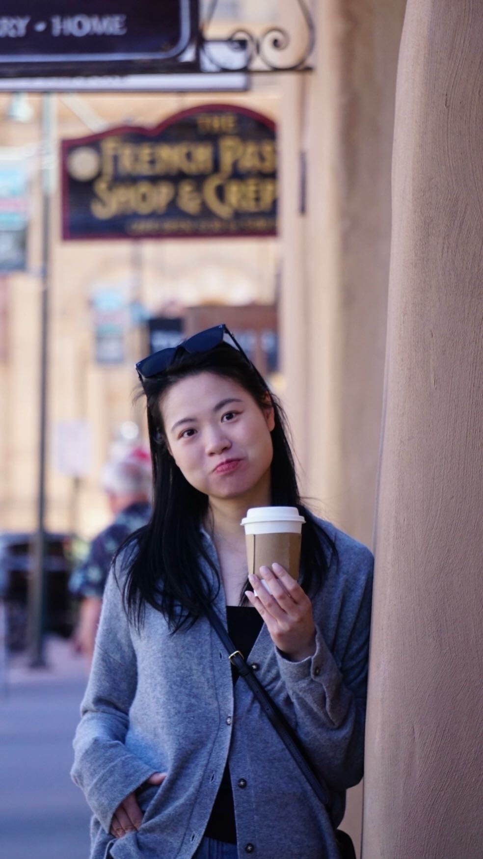 Celine holding a coffee outdoors