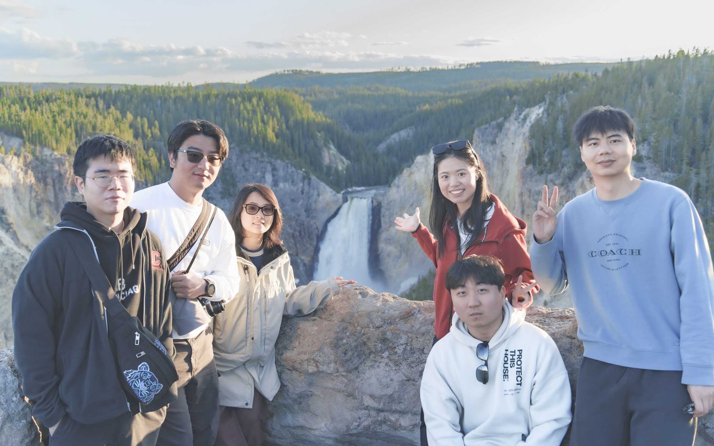 Friends gathered outdoors by a waterfall