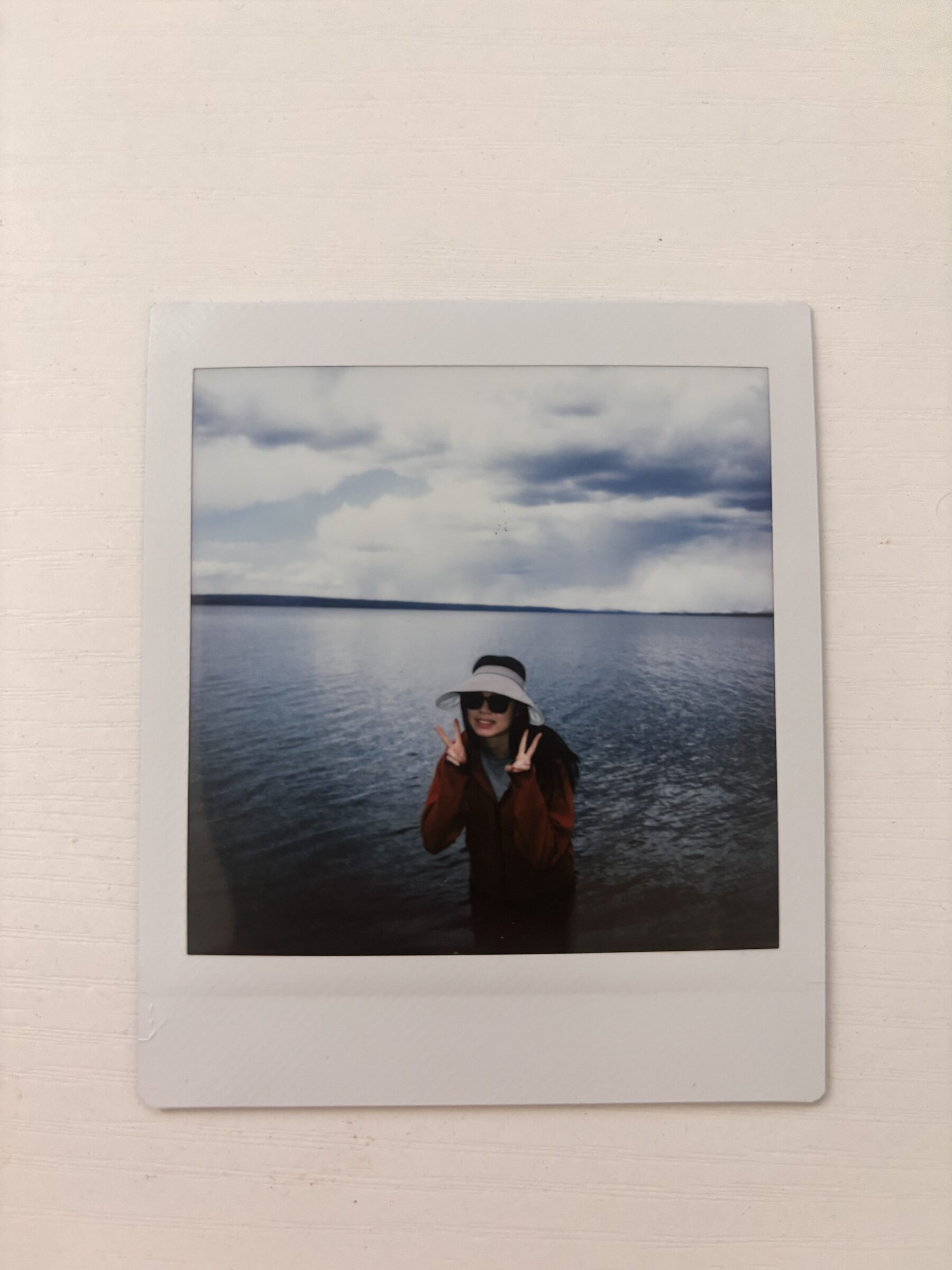 A person standing by a lake in a printed photo