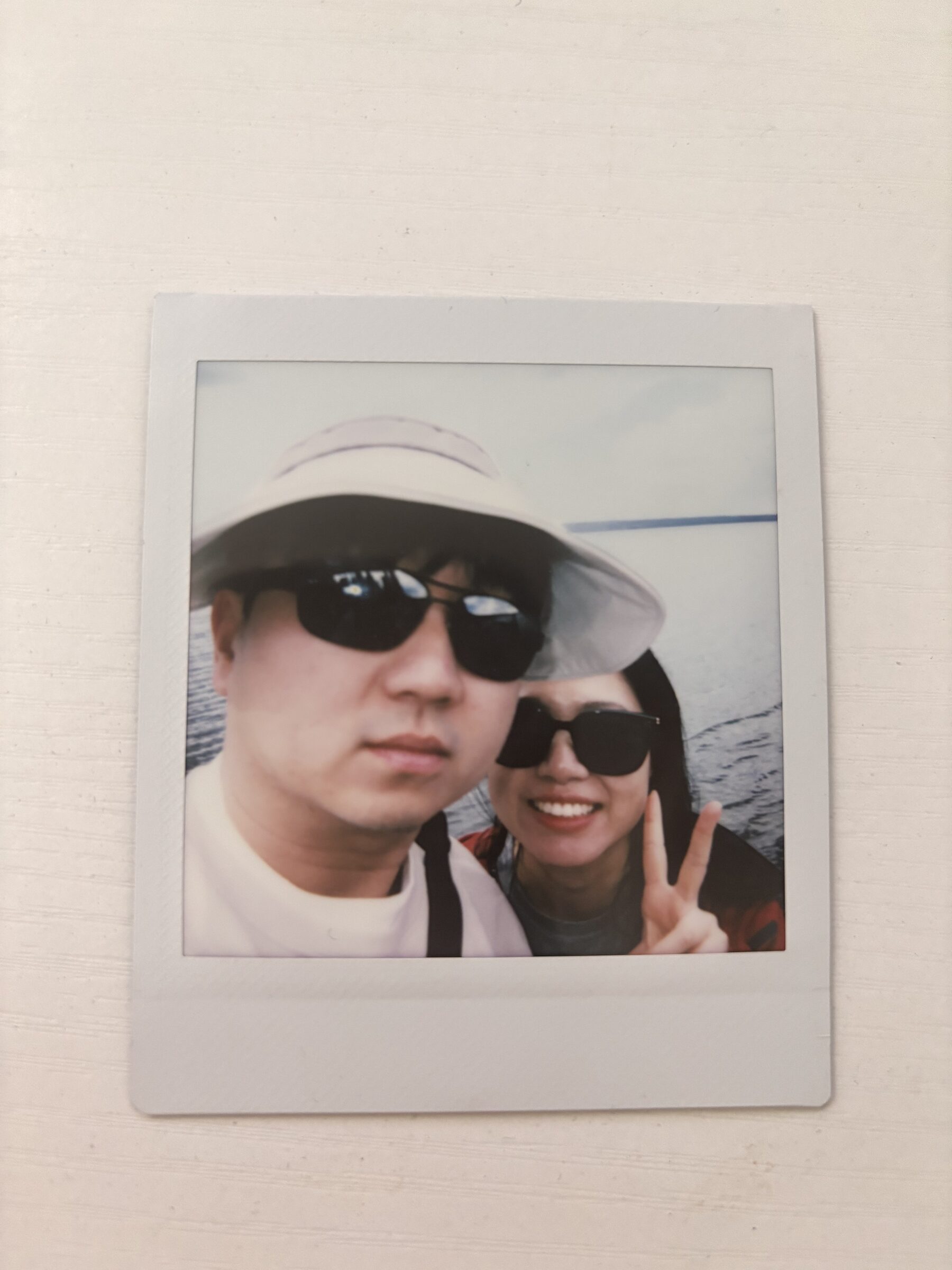 A couple smiling by the water in a printed photo